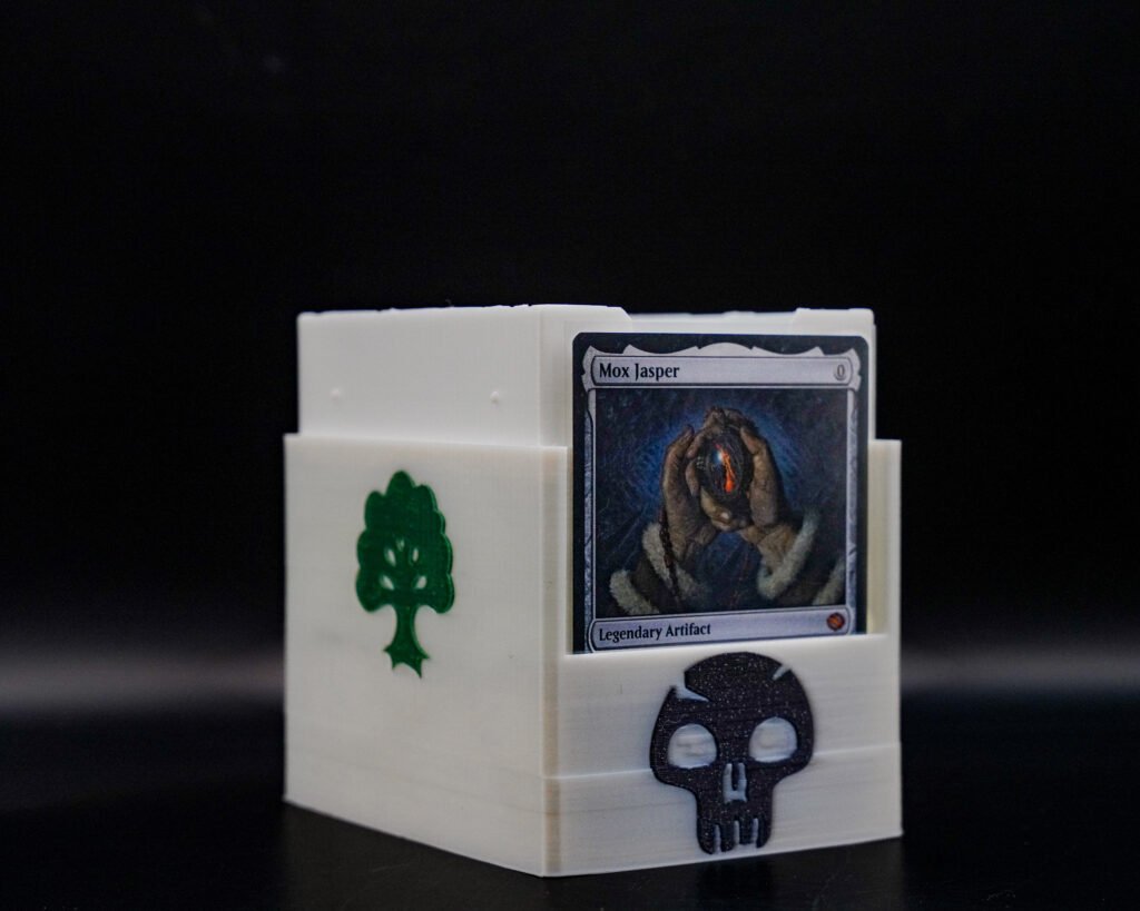 3D printed Magic: The Gathering card box with tree and skull icons, holds up to 100 sleeved cards, shown open with a card displayed inside