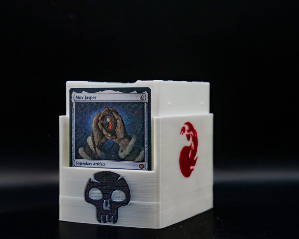 3D printed Magic: The Gathering card box with skull and dragon icons, holds up to 100 sleeved cards, shown open with a card displayed inside